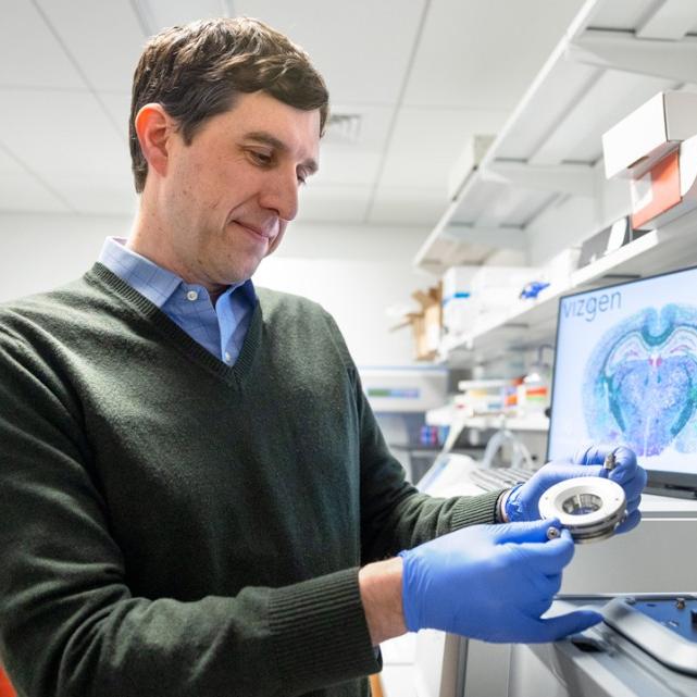 		Person wearing blue gloves examines an instrument
	