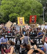 		 Black Lives Matter protest, masked people holding signs of men who have been killed
	