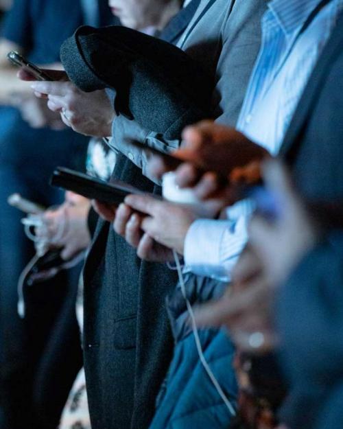 people in business clothes check smart phones