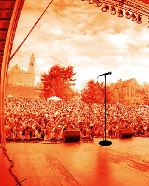 		Red-tinted image of a stage from the performers point of view, looking out at a large crowd outside
	