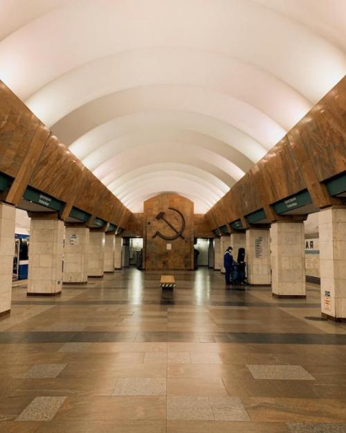 		Interior of a building with arched ceiling and smooth floors; Soviet symbol carved into far wall
	