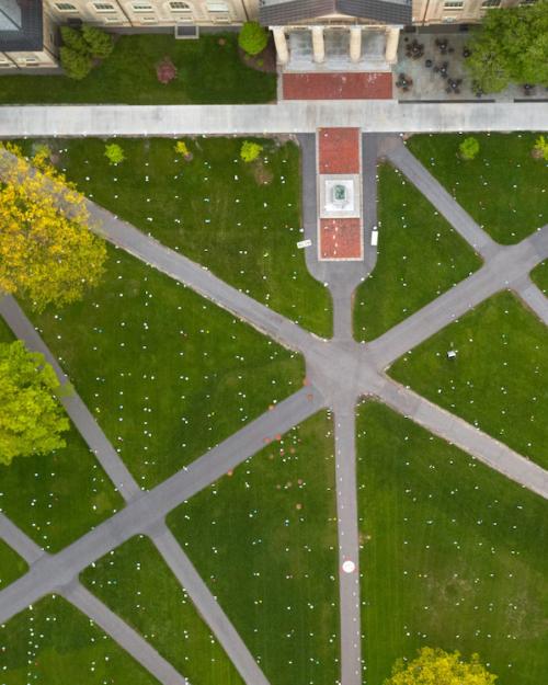 		Green lawn intersected by gray paths, seen from the air
	