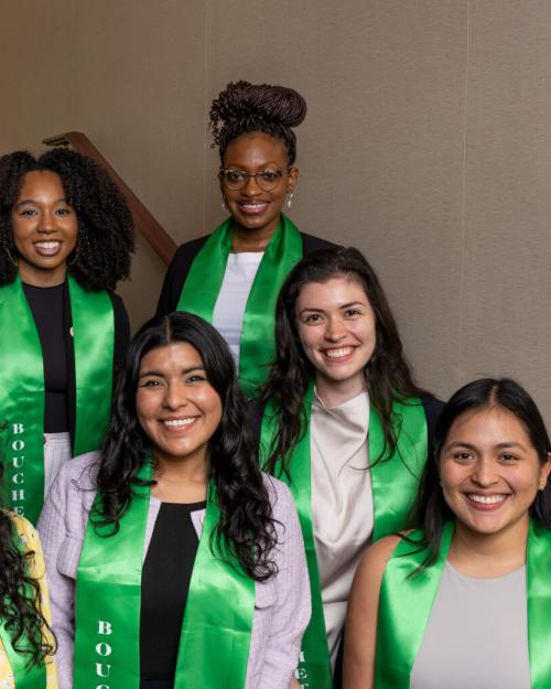 Seven people wearing green honor stoles