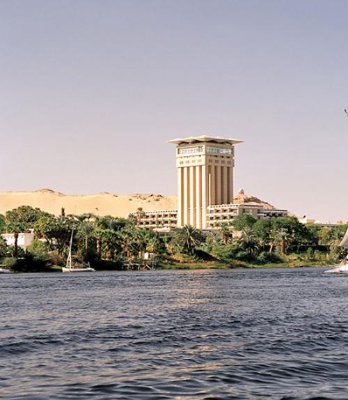 		 The Nile River passing a hotel, palm trees and a sandy hill
	