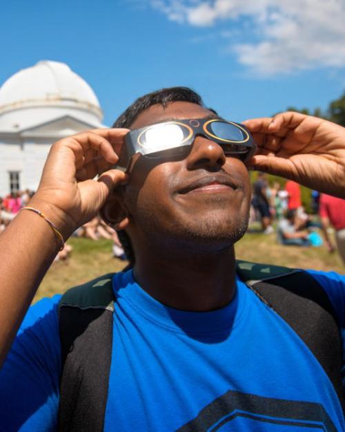 		 Student observing solar eclipse with special glasses
	
