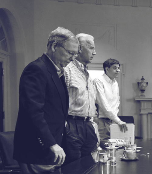  Three men stand at a table