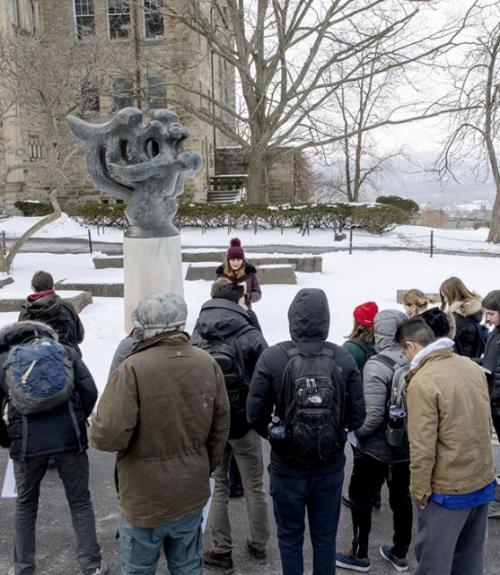  Students in Verity Platt&amp;#039;s course, Statues and Public Life, examine and analyze a statue outside Uris library.  