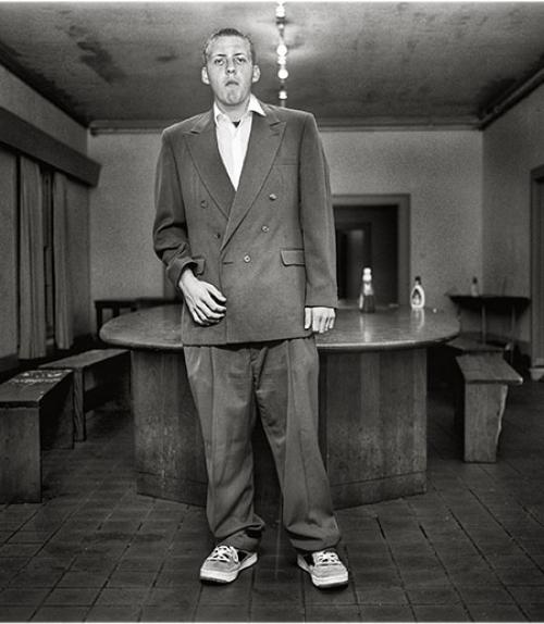  A fraternity brother in a suit standing in the living room. Credit/Copyright: Andrew Moisey