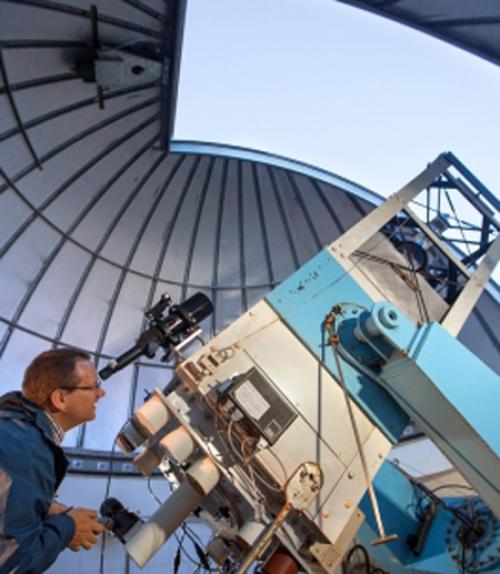 		 Astronomer looking through telescope
	
