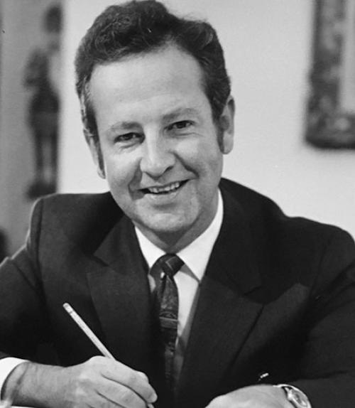		 Robert Plane smiling, holding a pencil
	