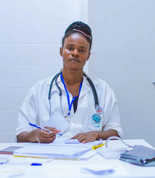 		 Black woman doctor sitting in chair with stethoscope around her neck and expression of exhaustion
	