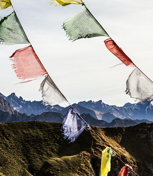 		 Colorful flags with mountains in the background
	