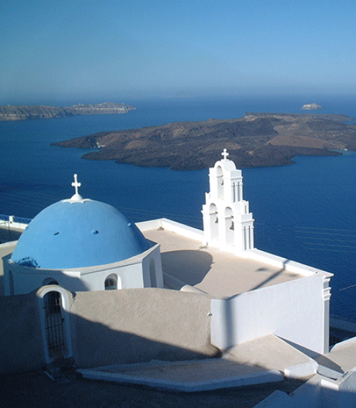 		 White Greek building against a blue sea: island of Santorini 
	