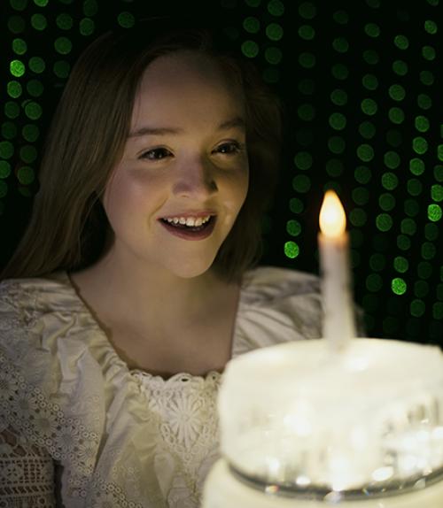 		 Girl looking at birthday cake
	