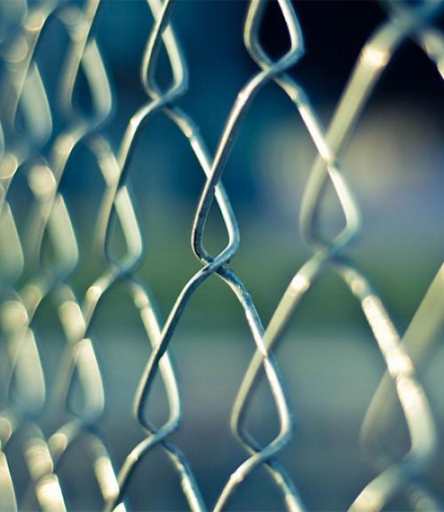 		 A chainlink fence on a blue background
	