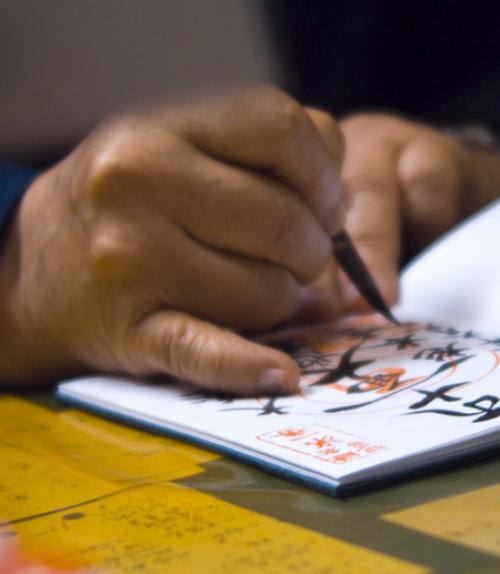 		 Hand drawing asian characters in a notebook
	