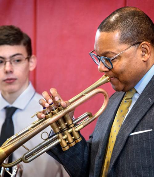 		 Wynton Marsalis showing a middle school student how to blow a trumpet
	