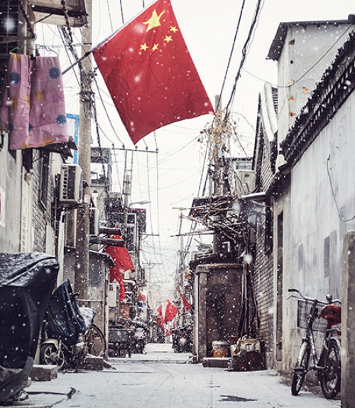 		 Narrow street with a red Chinese flag hanging
	