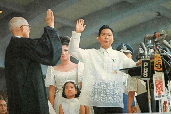Person at a podium, hand raised to take an oath