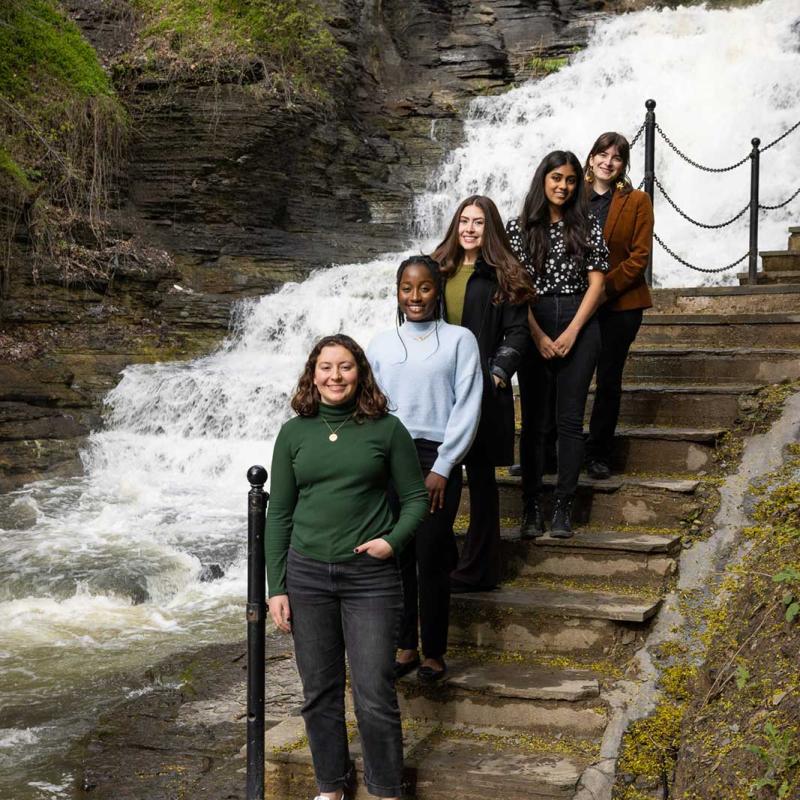 Students standing on a staircase overlooking a rushing waterfall