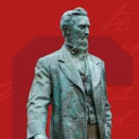 statue of Ezra Cornell against red background