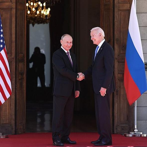 Two people in suits shake hands