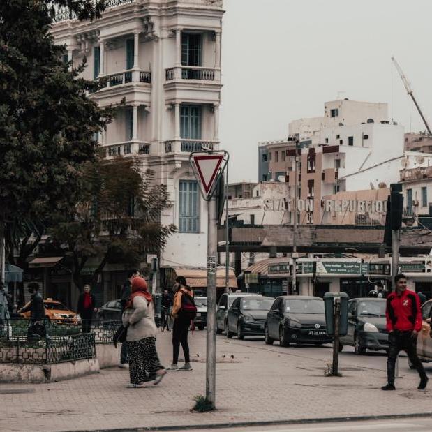 Busy street, white stone buildings, hazy sky