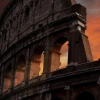 		Stone ruins of Roman Colosseum backed by red sunset
	
