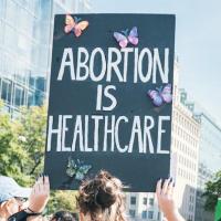 Person holding sign: 'Abortion is Health Care"