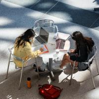 Two people study at a table, seen from above