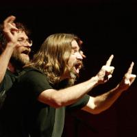 Two people performing with dramatic hand gestures and facial expressions