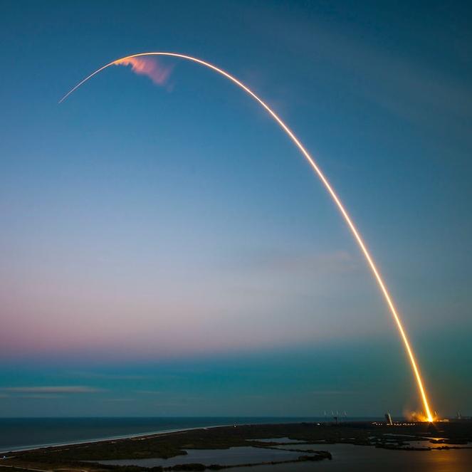 Yellow streak against a pale blue and pink sky; a missile launch