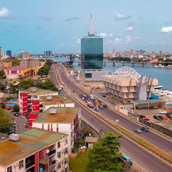 City street winds past modern buildings beside a river: Lagos, Nigeria
