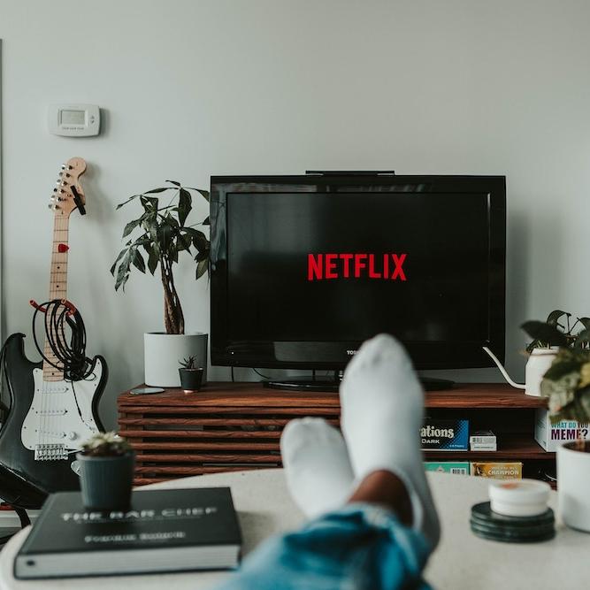 TV screen, socked feet on a coffee table