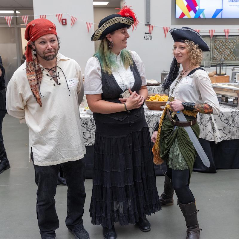 Three people dressed as pirates pose