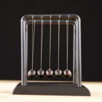 		Five metal balls hang from wires in a frame
	
