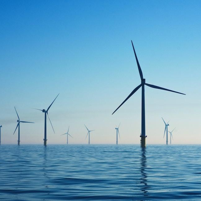 		Wind turbines in calm water against a blue dusk sky
	