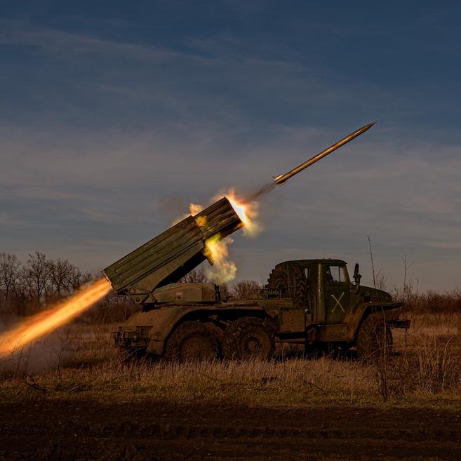 Military vehicle firing a missile while parked in a field