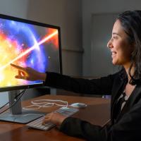		Person pointing to a brightly lit, colorful computer schreen
	