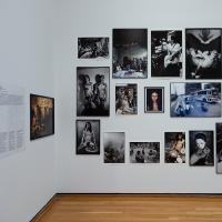 Images, most of them black and white, hung on a white museum wall
