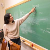 		woman showing Ukrainian words on chalkboard
	
