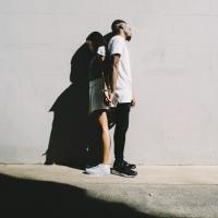 		Two people leaning back to back against a wall, shadowed
	