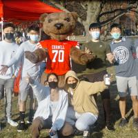 Seven students and the bear mascot, looking happy