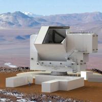 White blocky structure in a desert; mountains in background