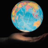 glowing earth globe, human hand