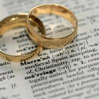 Two gold rings on a dictionary definition of 'marriage'