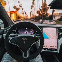 Interior of a self-driving car, looking out at palm trees