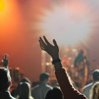 Band on stage, bright lights, worshippers