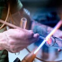 person holding glass to flame