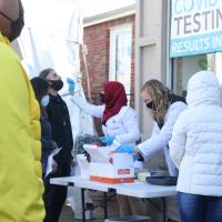 People administer COVID tests at an outdoor table